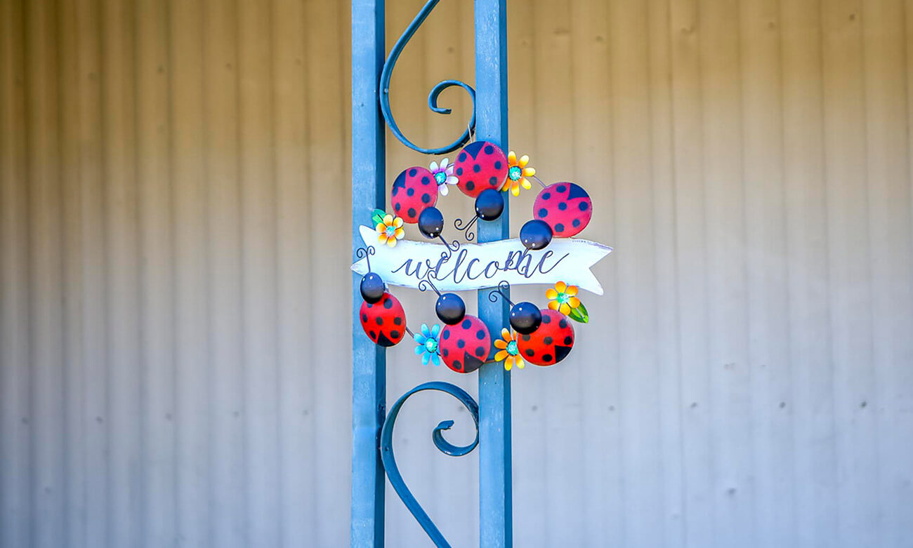 welcome ladybug decoration hanging on metal column in mobile home park